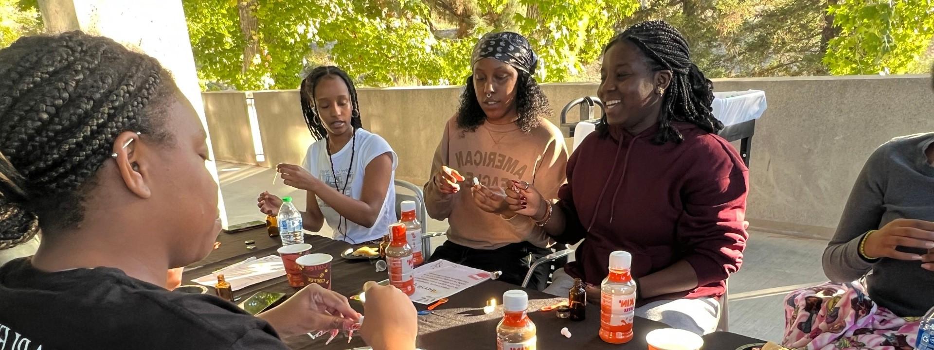 A group of students smiling and observing a spray bottle.